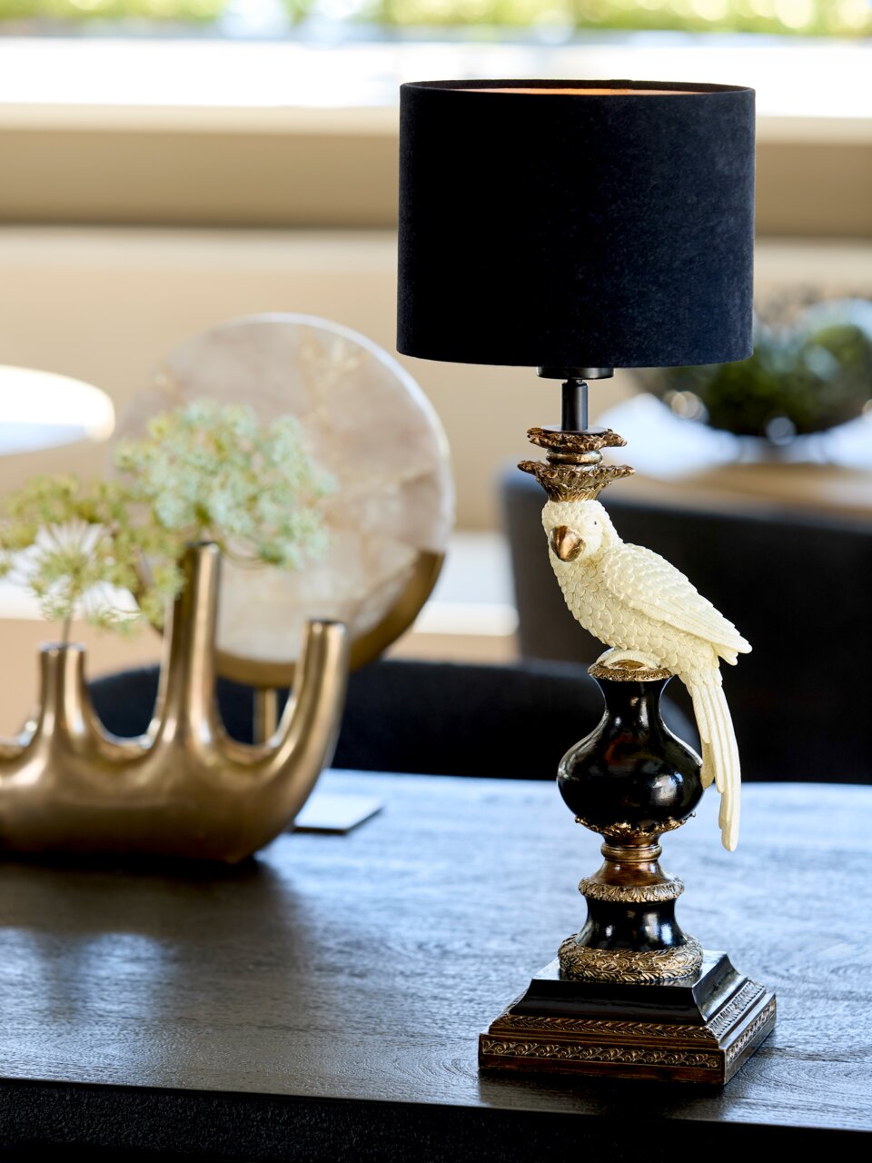 Eleganter Lampenschirm Zylinder mit schwarzem Stoff und dekorativem Papageienfuß, seitliche Perspektive auf einem Tisch.