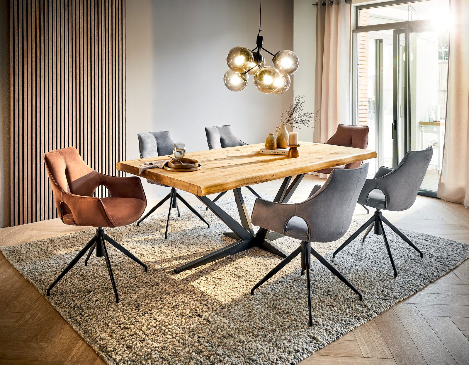 Moderner Esstisch aus Holz mit Metallgestell, umgeben von stilvollen Stühlen in einem hellen, einladenden Esszimmer. Perspektive: seitliche Ansicht.