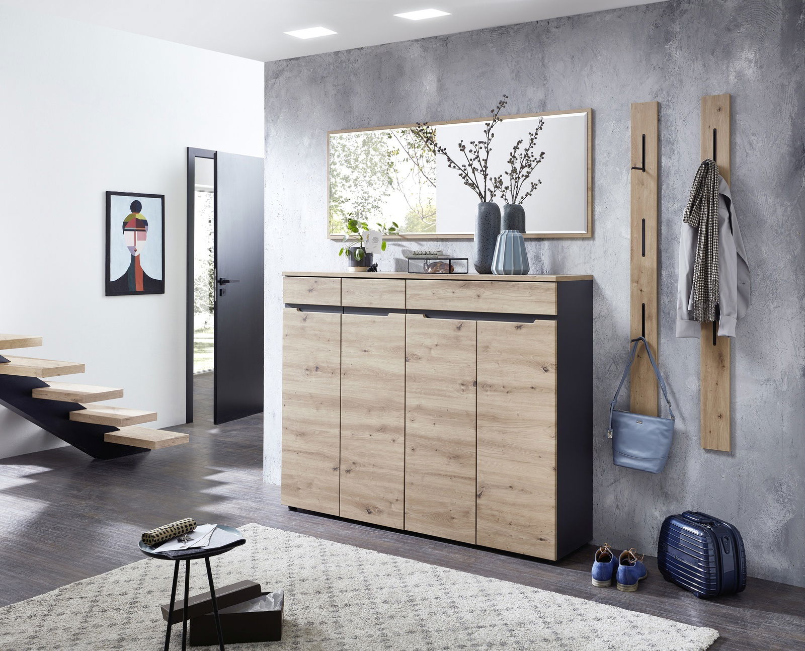 Moderner Eingangsbereich mit einem XL-Schuh- und Garderobenschrank in Holzoptik, flankiert von zwei schmalen Garderobenpaneelen. Perspektive von vorne.