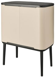 Moderner cremefarbener Abfalleimer mit schwarzen Beinen, seitliche Perspektive