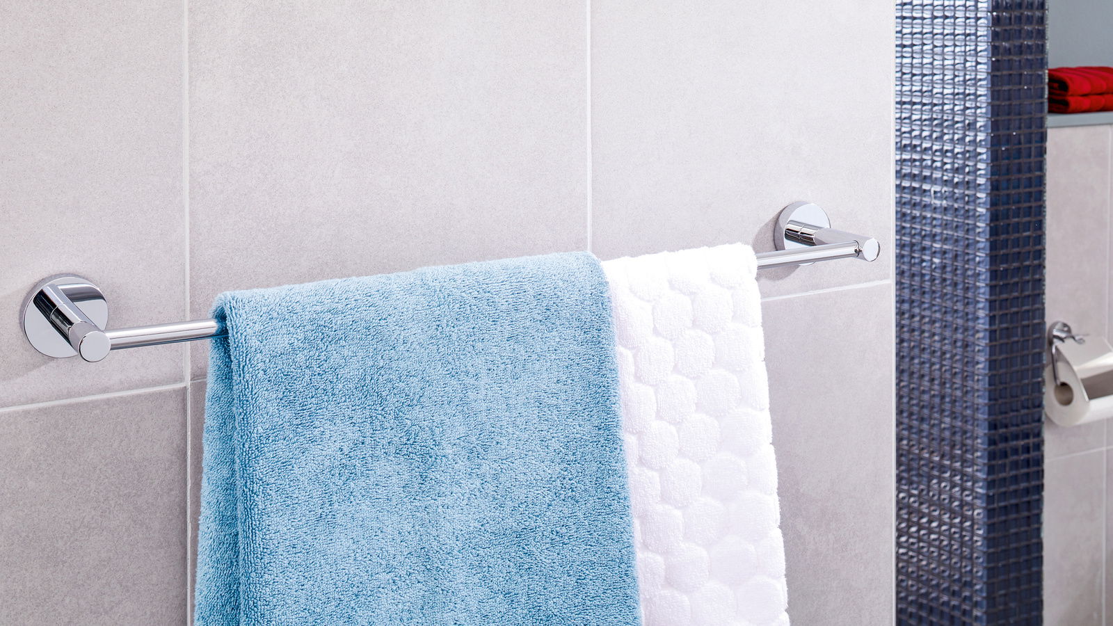 Ansicht einer modernen, verchromten Handtuchstange mit zwei Handtüchern, montiert an einer Badezimmerwand.