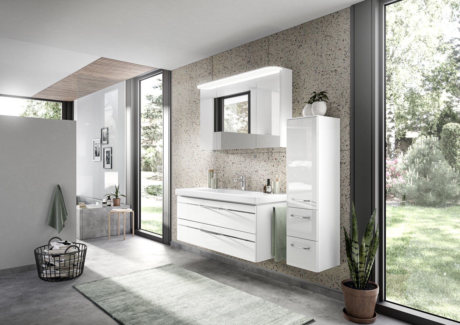 Moderner Badblock in einem hellen Badezimmer mit großen Fenstern, bestehend aus einem weißen Waschtisch mit Schubladen und einem hohen, schmalen Schrank. Perspektive von schräg vorne.