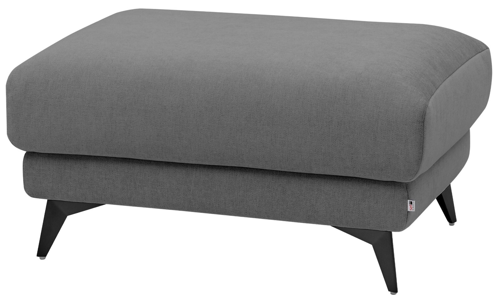 Grauer, gepolsterter Sofa-Hocker/Fußhocker mit Stoffbezug und schwarzen, schräg stehenden Metallfüßen, freigestellt vor weißem Hintergrund, Ansicht schräg von vorne rechts.