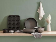 Eine Springform mit 26 cm Durchmesser, präsentiert auf einem Holzregal in einer modernen Küchenszene, umgeben von weiteren Backformen und Küchenaccessoires.