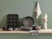 Eine Springform mit 26 cm Durchmesser, präsentiert auf einem Holzregal in einer modernen Küchenszene, umgeben von weiteren Backformen und Küchenaccessoires.