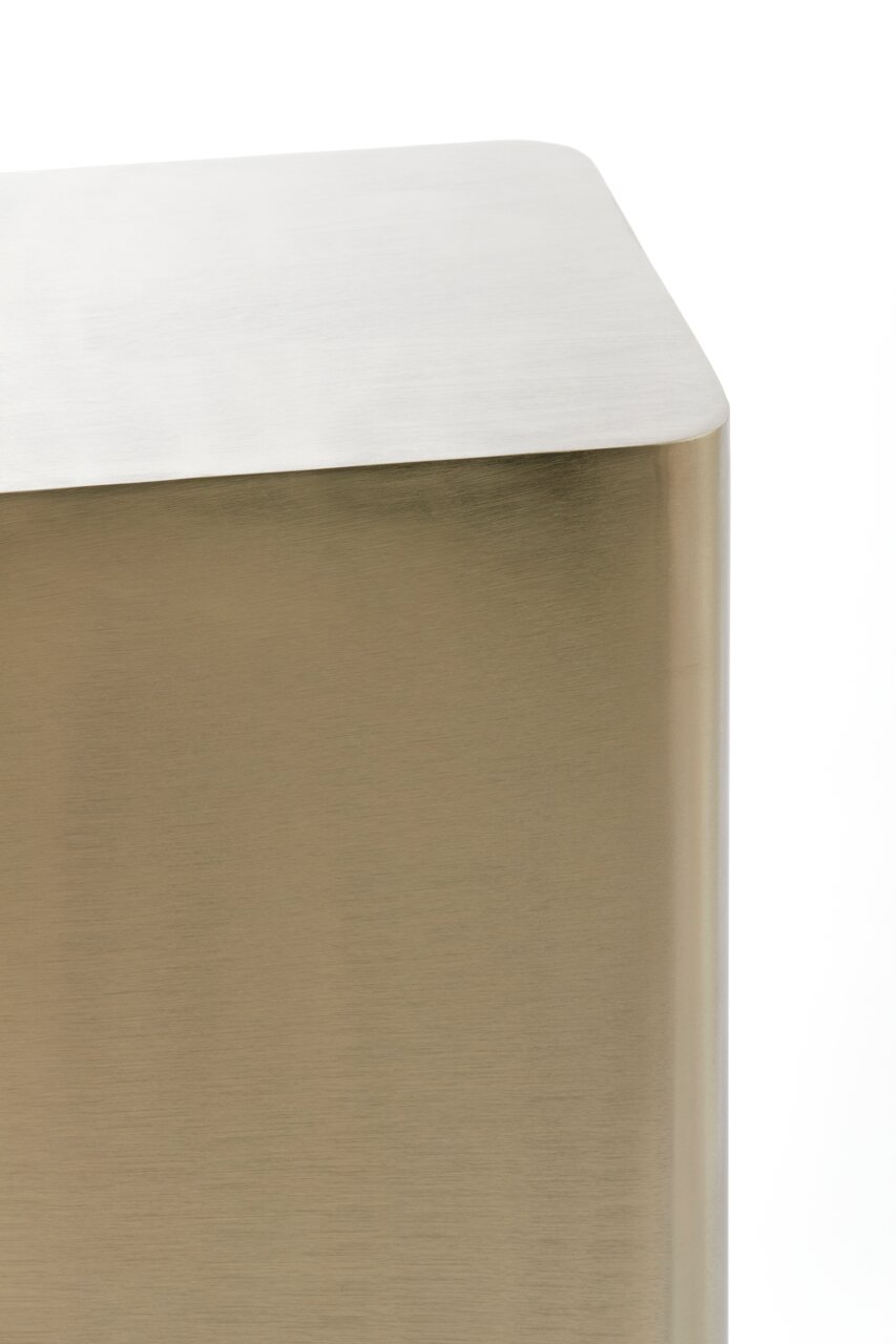 Nahaufnahme einer modernen, rechteckigen Säule mit abgerundeten Ecken in metallischer Optik, seitliche Perspektive.