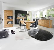 Moderner Essbereich mit einem großen Esstisch aus Holz, umgeben von schwarzen Stühlen. Der Raum ist hell und stilvoll eingerichtet, mit einem großen Fenster im Hintergrund. Perspektive: Frontalansicht auf den Esstisch.