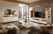 Een blik op de woonkamer met de moderne wandcombinatie FRESNO, bestaande uit een dressoir, salontafel en tv-meubel in hout- en wittinten, met decoratieve verlichting en stijlvolle accessoires.