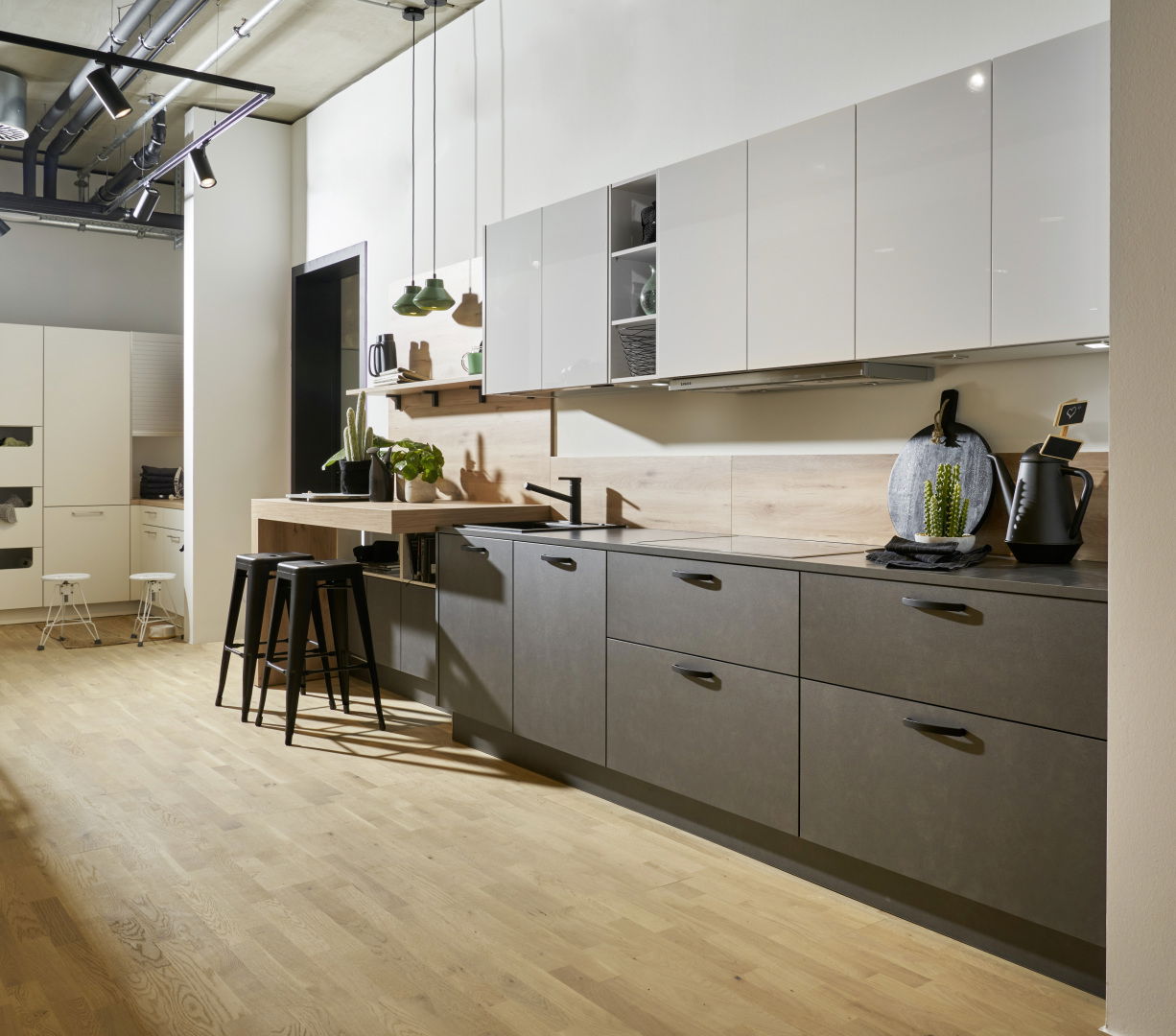 Moderne Küche mit eleganten grauen Schränken, hellen Holzakzenten und Barhockern.