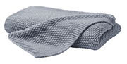 Graue Strickdecke 130x170 cm aus der Zurbrüggen Decken-Serie, gefaltet und aus seitlicher Perspektive fotografiert.
