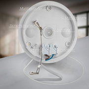 Close-up van de montageplaat van een witte plafondlamp met montagelijnen, veiligheidsanker, afdichtring en L/N-aansluitklemmen; perspectief: frontaal van binnenuit in de behuizing.