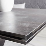 Nahaufnahme der Tischkante eines modernen Esstisches mit dunkler, glatter Oberfläche.