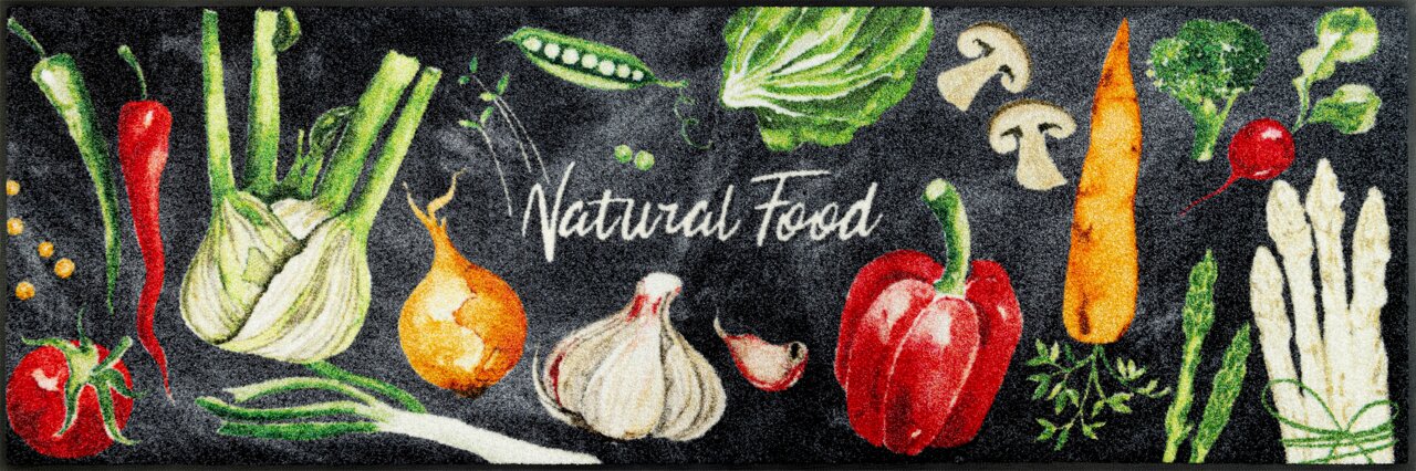 Teppich mit bunten Gemüsemotiven und dem Schriftzug 'Natural Food', aus der Vogelperspektive betrachtet.