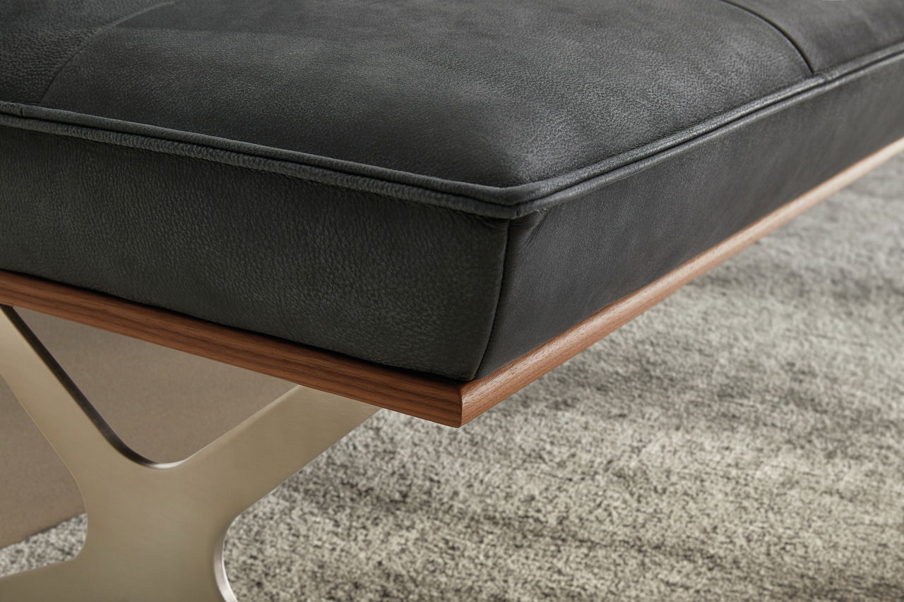 Nahaufnahme einer modernen Bank mit schwarzem Polster und Holzrahmen, seitliche Perspektive.