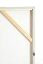 Achteraanzicht van een opgespannen wit canvas in een witte houten lijst, met diagonale houten verstevigingslat en metalen ophanghaak