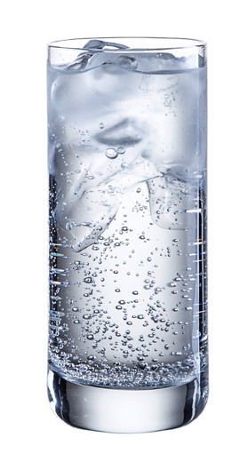 Ein hohes, schlankes Trinkglas mit kohlensäurehaltigem Wasser und Eiswürfeln, seitliche Perspektive.