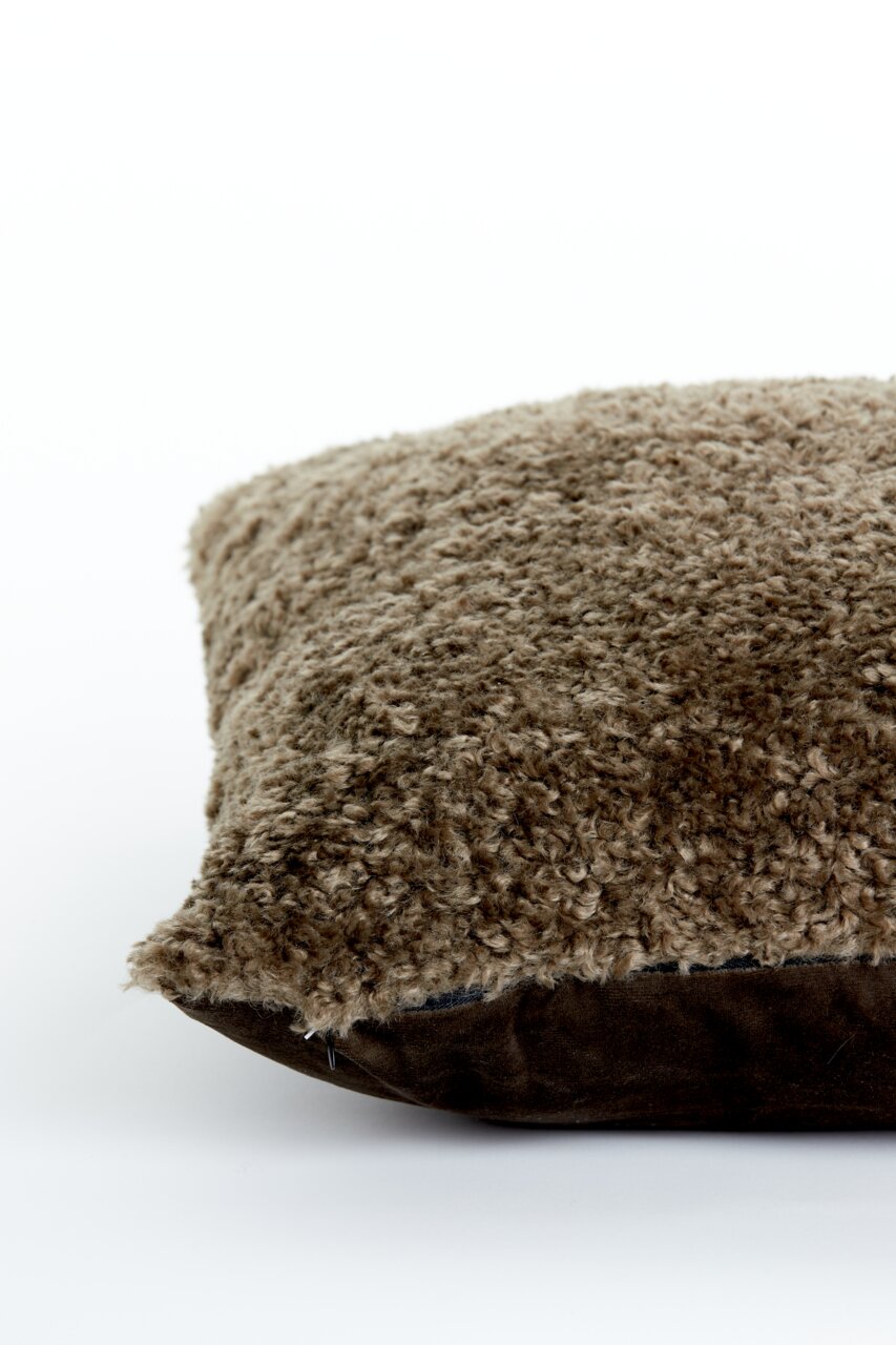 Nahaufnahme eines braunen Kissens mit flauschiger Textur, seitliche Perspektive.