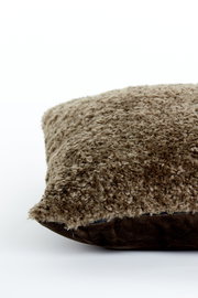 Nahaufnahme eines braunen Kissens mit flauschiger Textur, seitliche Perspektive.