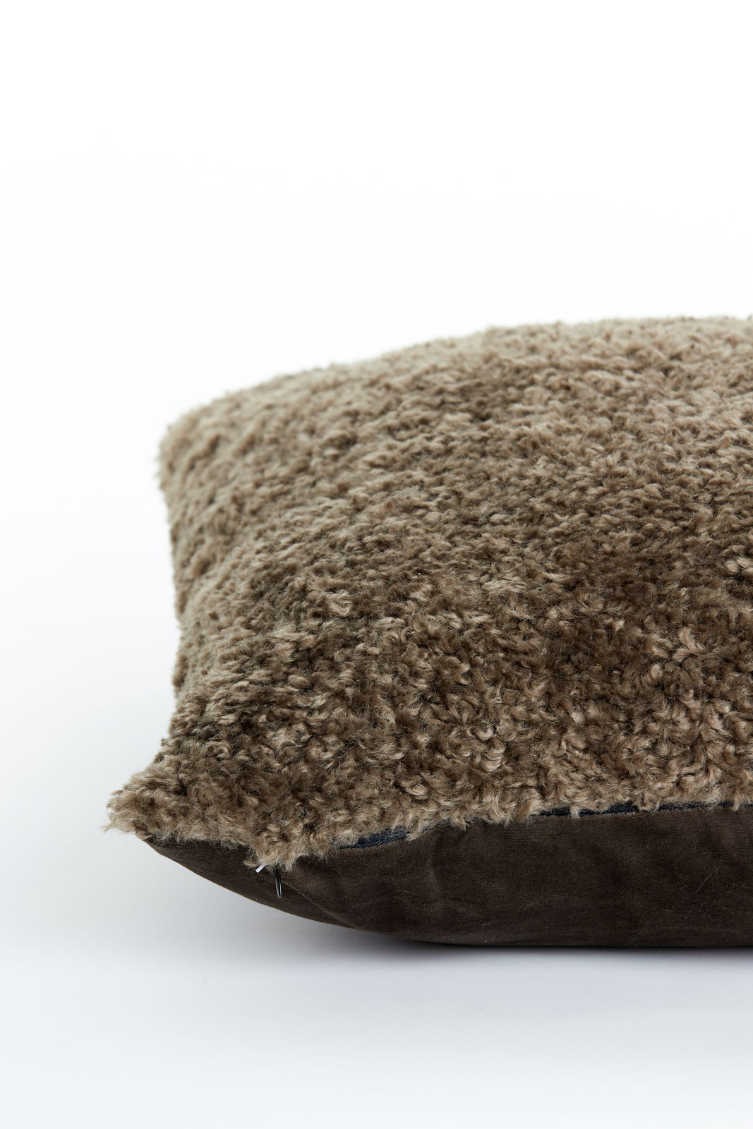 Nahaufnahme eines braunen Kissens mit flauschiger Textur, seitliche Perspektive.