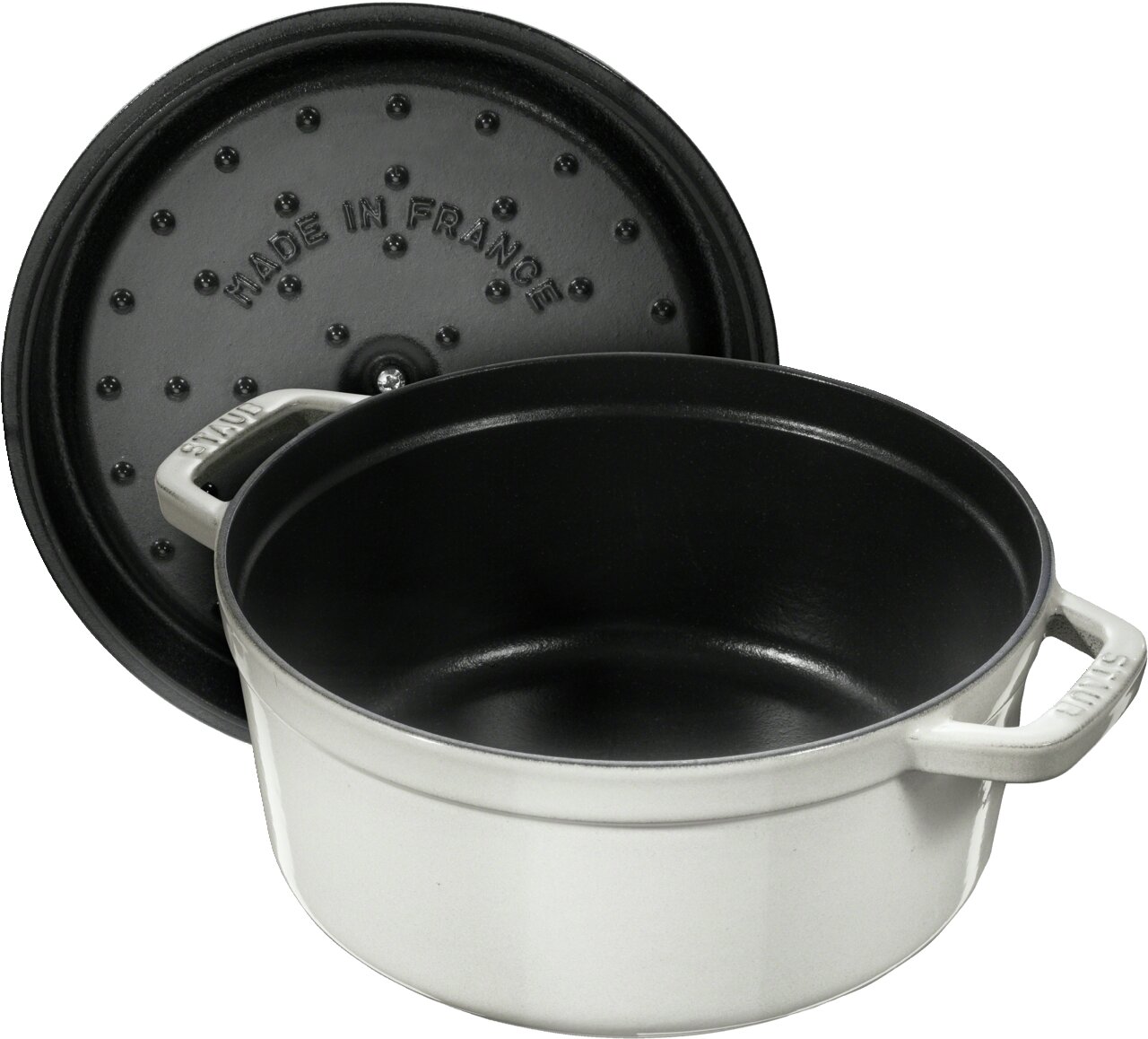 Runde weiße Bräter Cocotte 28cm mit schwarzer Innenbeschichtung, Deckel im Hintergrund, Perspektive von schräg oben