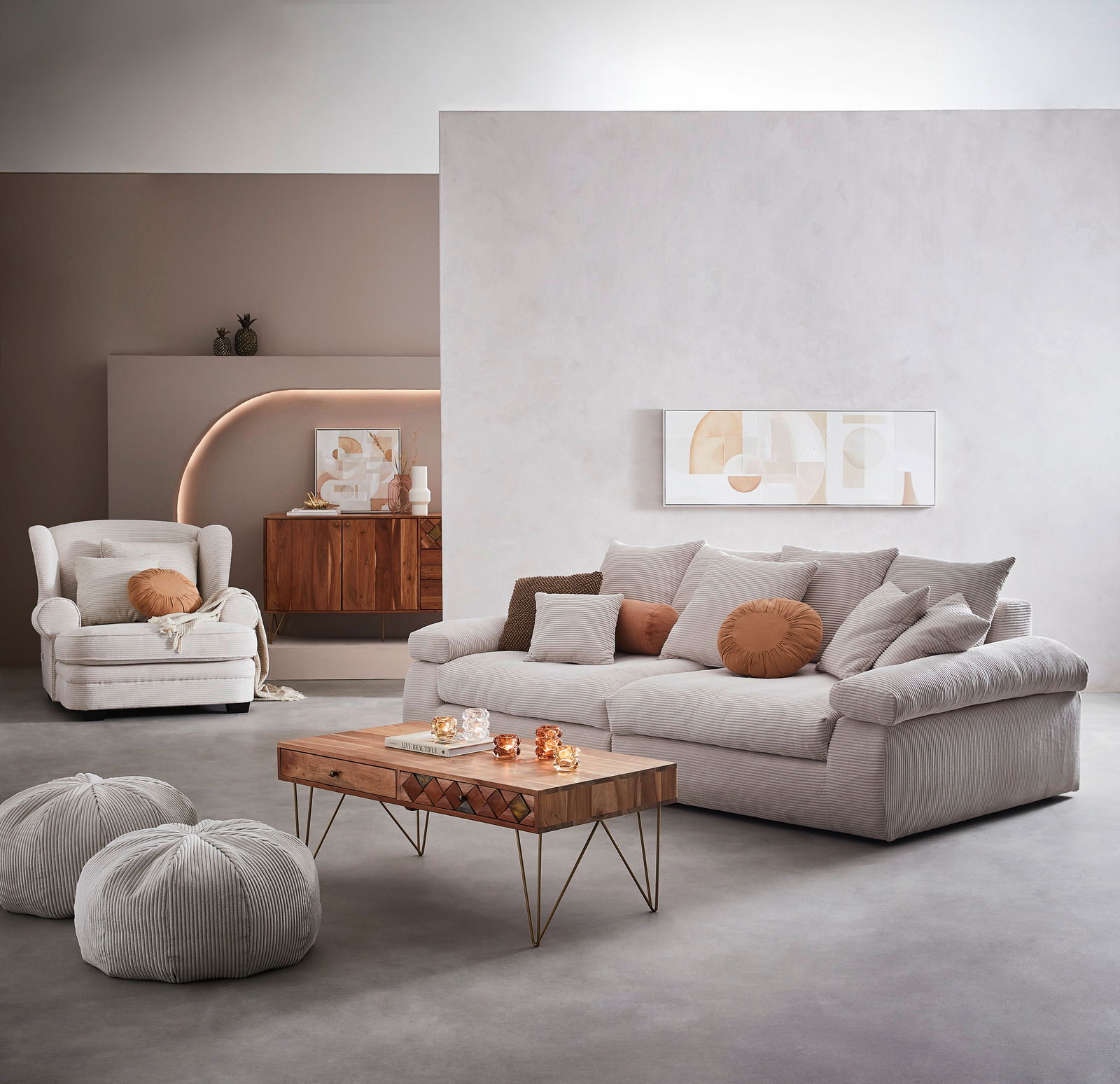 Gemütliches Big-Sofa in einem modernen Wohnzimmer, frontal fotografiert, mit mehreren Kissen in neutralen Tönen und einem Couchtisch aus Holz im Vordergrund.