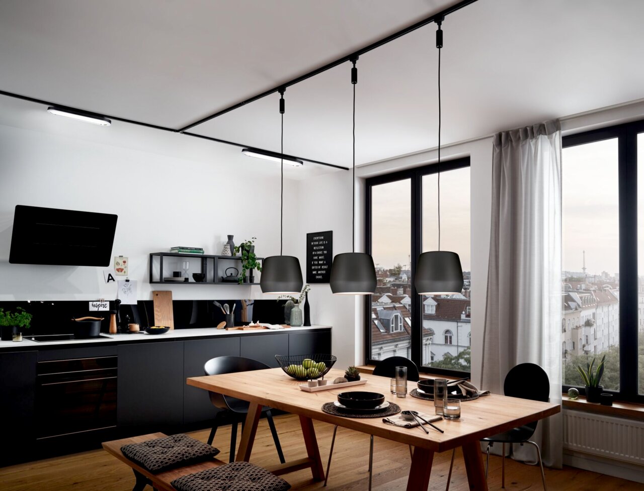 Moderne Pendelleuchten in einer stilvollen Küche, aus der Perspektive des Esstisches fotografiert.