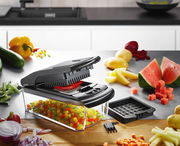 Würfel- und Stifteschneider Treppo in einer modernen Küche, seitliche Perspektive, umgeben von geschnittenem Gemüse und Obst.