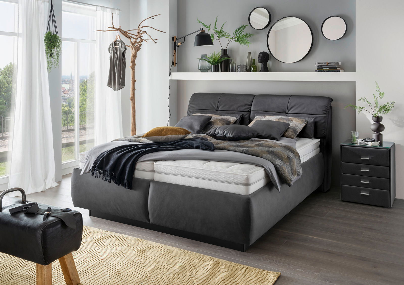 Modernes Polsterbett in einem stilvoll eingerichteten Schlafzimmer, seitliche Perspektive.