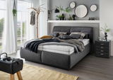 Modernes Polsterbett in einem stilvoll eingerichteten Schlafzimmer, seitliche Perspektive.