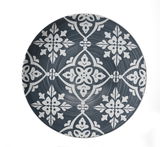 Vogelperspektive auf einen dekorativen Teller mit weißem, floralem Muster auf dunkelgrauem Hintergrund.