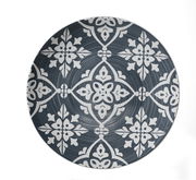 Vogelperspektive auf einen dekorativen Teller mit weißem, floralem Muster auf dunkelgrauem Hintergrund.