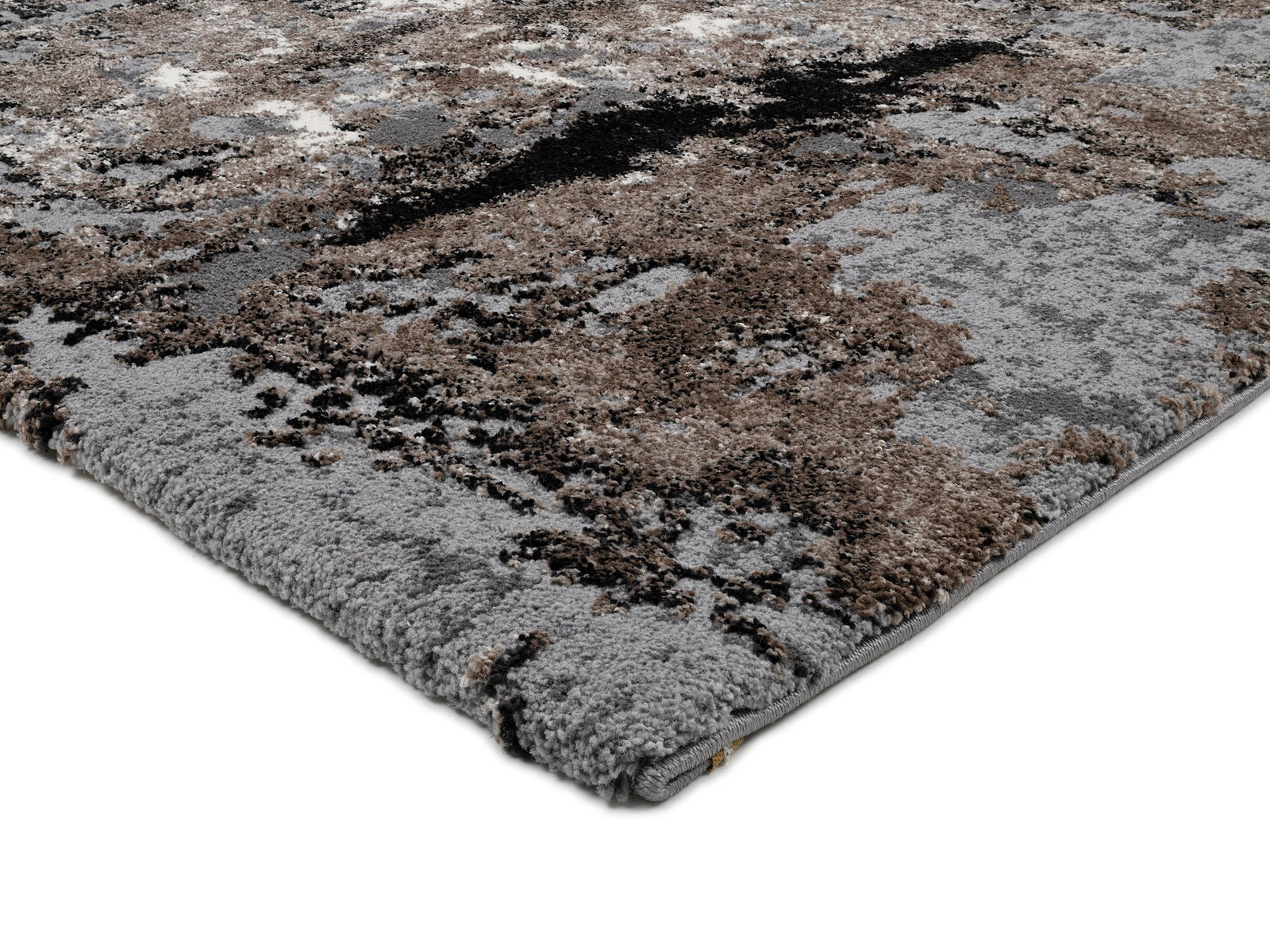 Nahaufnahme eines modernen Teppichs mit abstraktem Muster in Grau- und Brauntönen, perspektivisch von der Seite aufgenommen.