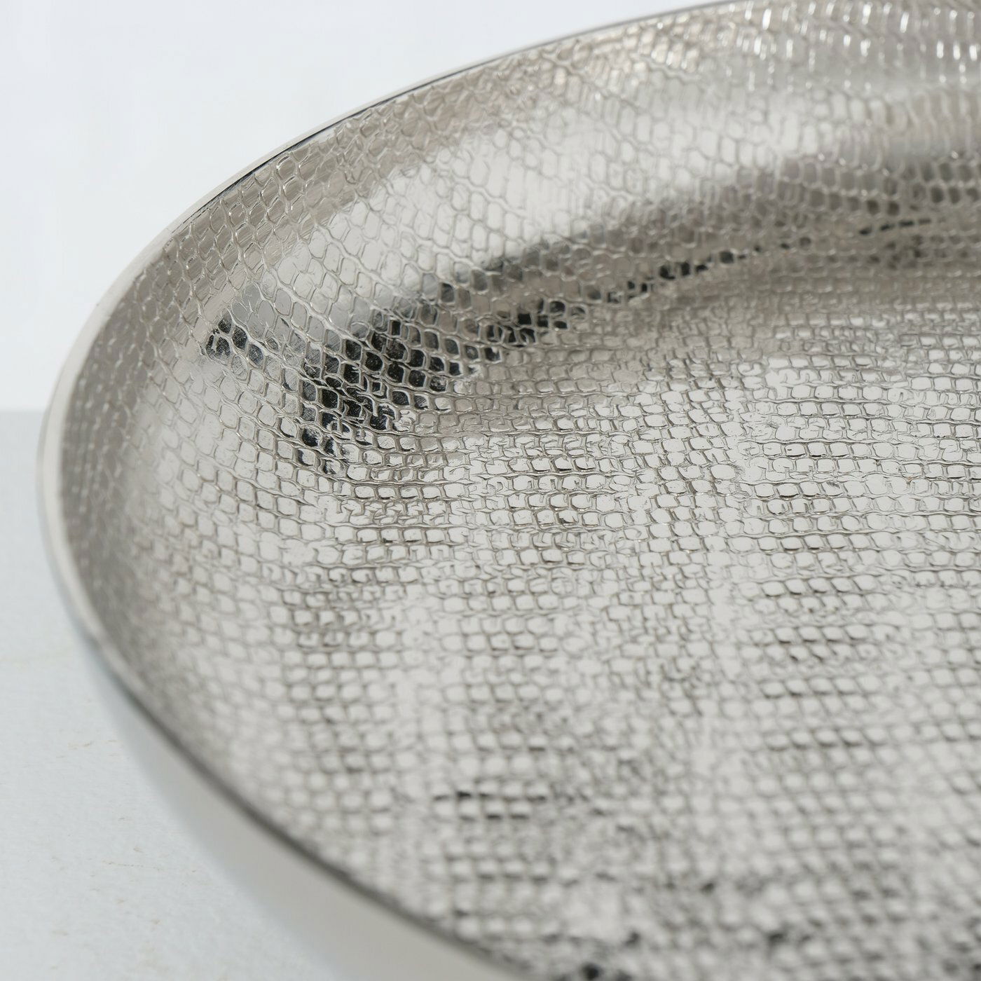 Nahaufnahme einer silbernen Etagere mit strukturierter Oberfläche, seitliche Perspektive