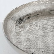 Nahaufnahme einer silbernen Etagere mit strukturierter Oberfläche, seitliche Perspektive