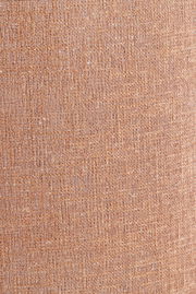 Nahaufnahme eines strukturierten, beige-braunen Lampenschirms aus Stoff.