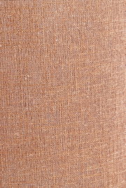 Nahaufnahme eines strukturierten, beige-braunen Lampenschirms aus Stoff.