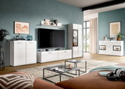Modernes Wohnzimmer mit weißer, hochglänzender Wohnwand (Lowboard, Vitrine, Sideboards und Wandregal) vor petrolfarbener Wand, TV mittig, aufgenommen in frontaler Perspektive mit leichter Weitwinkelansicht.