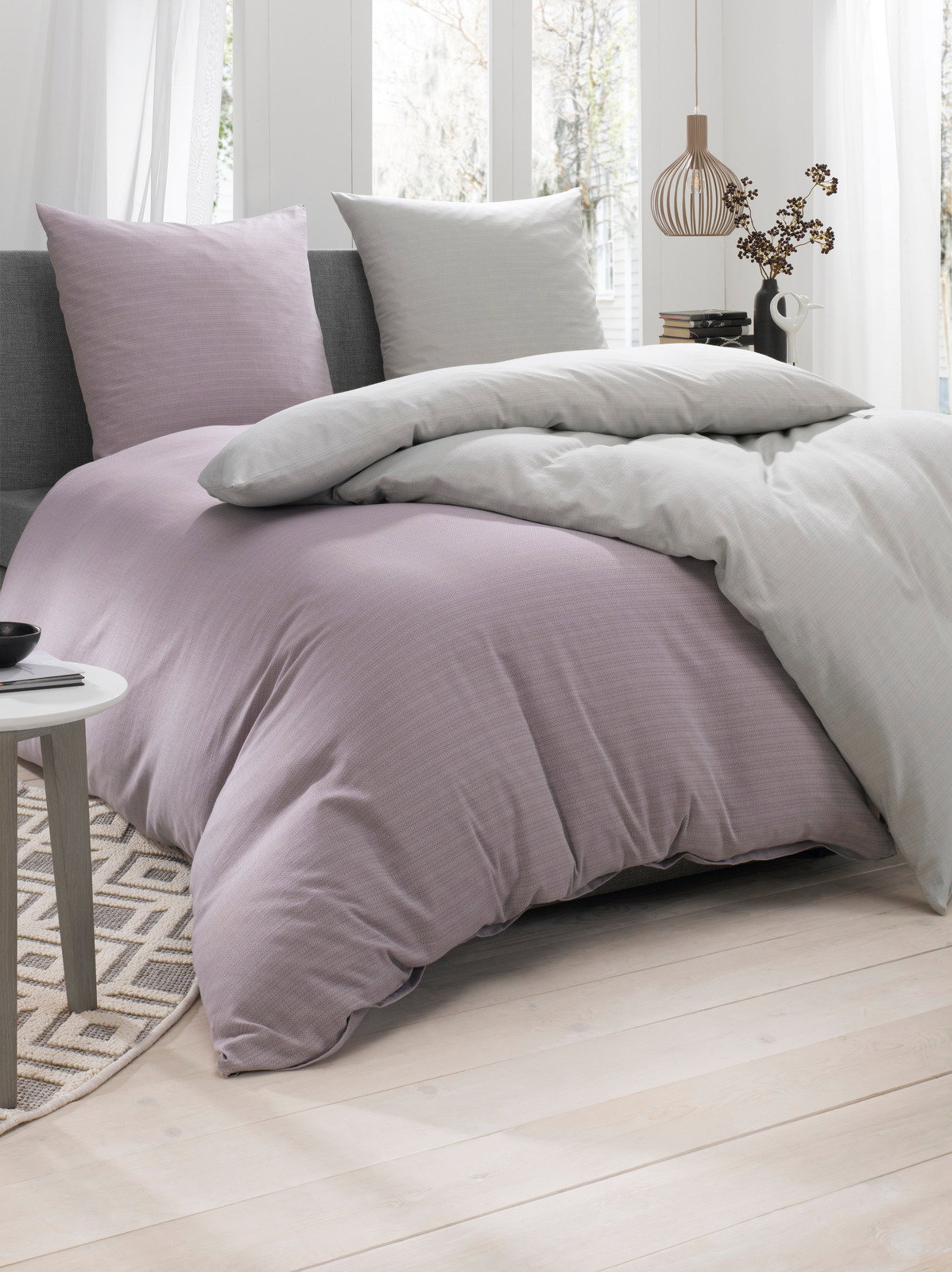 Bettwäsche-Set in sanften Pastelltönen auf einem Bett, seitliche Perspektive