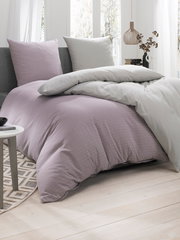 Bettwäsche-Set in sanften Pastelltönen auf einem Bett, seitliche Perspektive