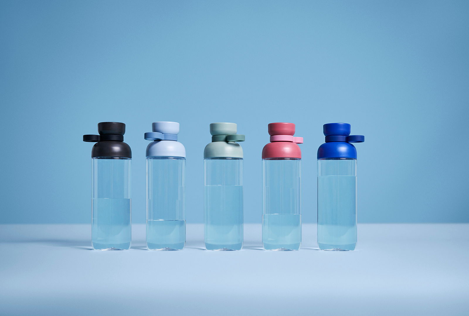 Mepal Trinkflasche Nordic Black VITA Fünf Trinkflaschen in verschiedenen Farben (schwarz, hellblau, grün, rosa, blau) stehen nebeneinander auf einer ebenen Fläche, frontal betrachtet.