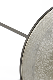 Nahaufnahme eines runden Beistelltisches mit strukturiertem Metallrahmen und glatter Oberfläche, seitliche Perspektive.