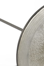 Nahaufnahme eines runden Beistelltisches mit strukturiertem Metallrahmen und glatter Oberfläche, seitliche Perspektive.