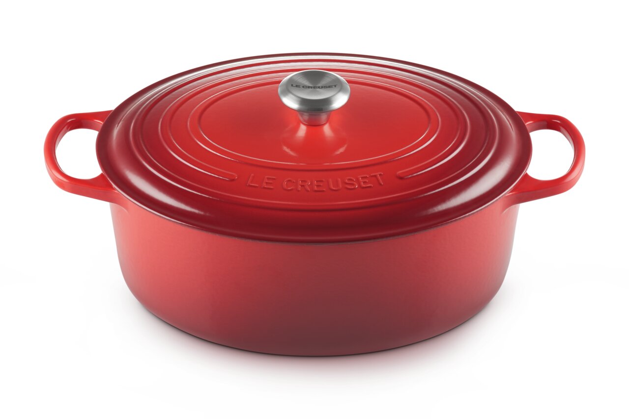 LE CREUSET Bräter Rund 24cm Kirschrot SIGNATURE Roter runder Bräter mit Deckel und Griffen, von oben leicht seitlich betrachtet.