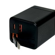 Schwarzes USB-Ladegerät mit EU-Stecker und zwei USB-Anschlüssen (orange), Nahaufnahme in schräger Vorderansicht von oben auf weißem Hintergrund