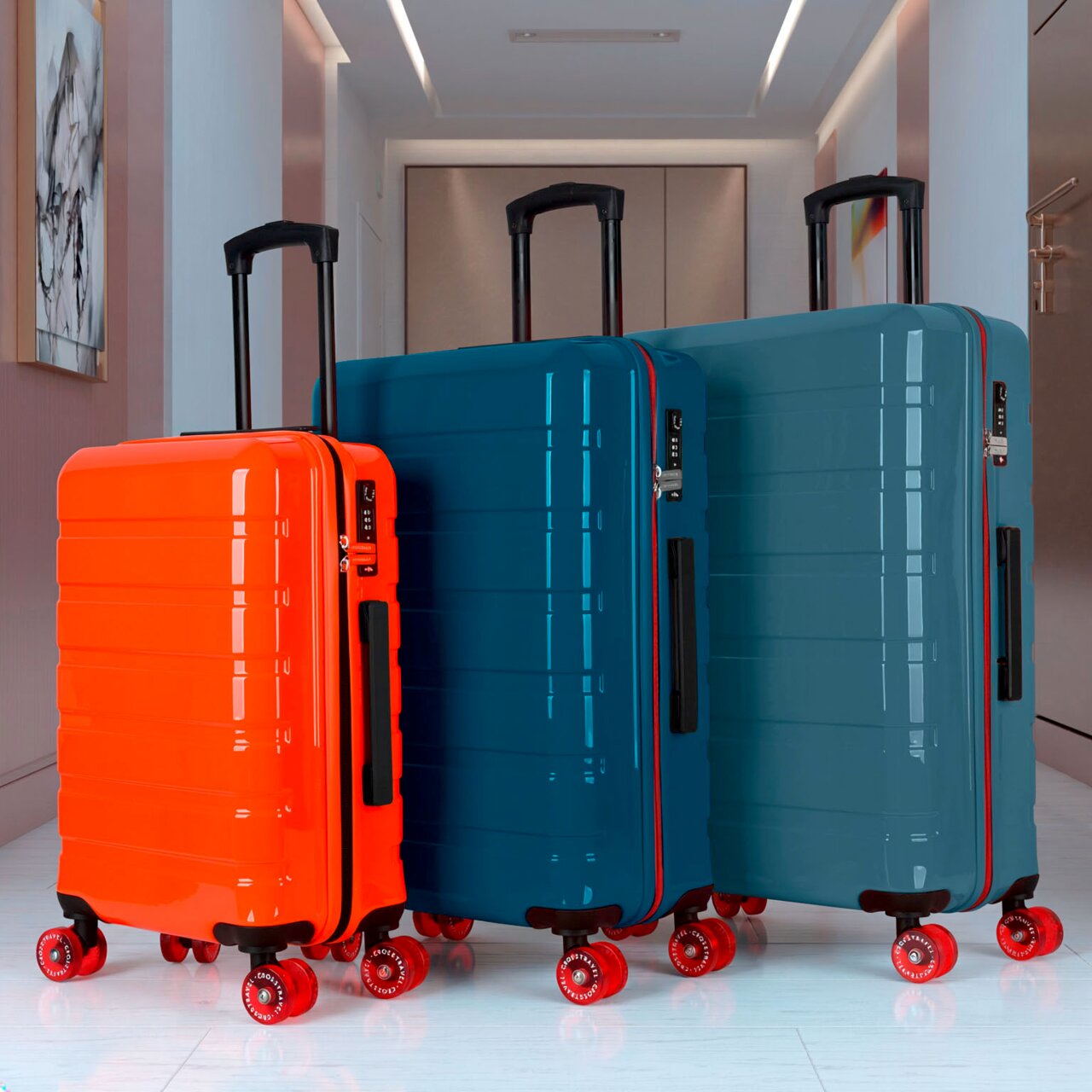 Drei Hartschalen-Trolleys mit Teleskopgriff und roten Rollen (orange, petrol und blaugrün) in einem Flur, fotografiert aus niedriger Frontperspektive.