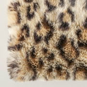 Nahaufnahme einer flauschigen Decke mit Leopardenmuster, von oben betrachtet.