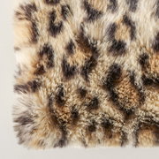 Nahaufnahme einer flauschigen Decke mit Leopardenmuster, von oben betrachtet.