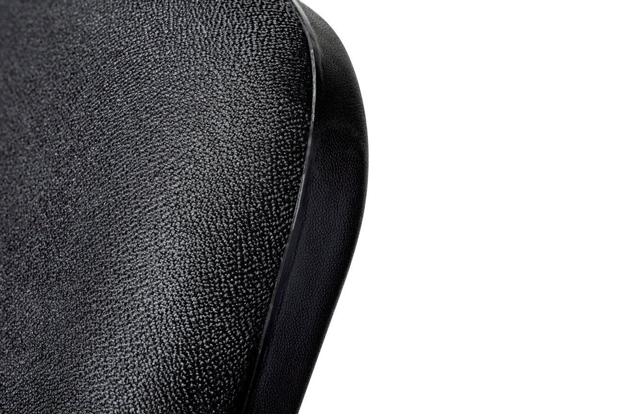 Nahaufnahme der Rückenlehne eines schwarzen Besucherstuhls mit texturierter Oberfläche, seitliche Perspektive