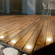 Eingelassene LED-Bodenleuchten auf einer Holzterrasse, seitliche Perspektive