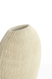 Nahaufnahme einer cremefarbenen Vase mit geriffelter Textur, seitliche Perspektive